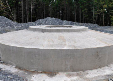Une base d'éolienne terminée : le socle circulaire de béton et son anneau d'ancrage