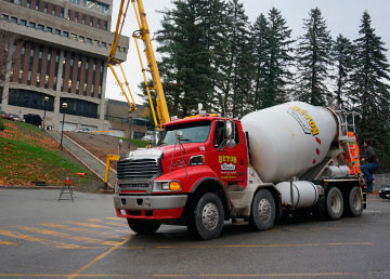 Une bétonnière de Béton Chevalier devant le CEGEP de Sherbrooke, la grue du chantier derrière