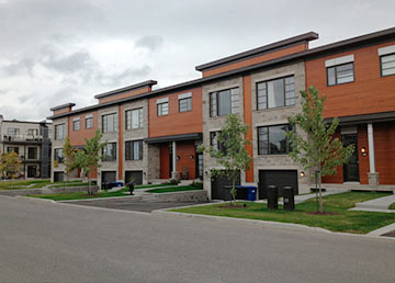 Un second développement résidentiel : maisons de ville colorées, rue et trottoirs neufs